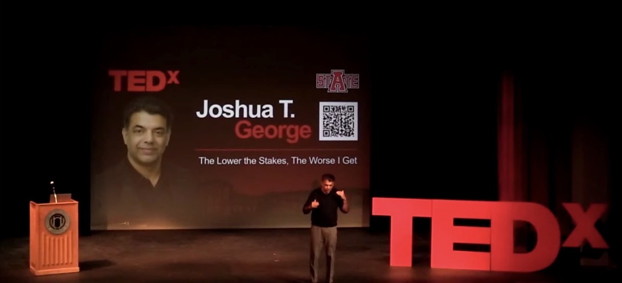 Joshua T. George on stage at TEDxArkansasStateUniversity, with his name and talk title on screen